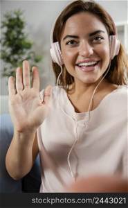 woman with headphones waving