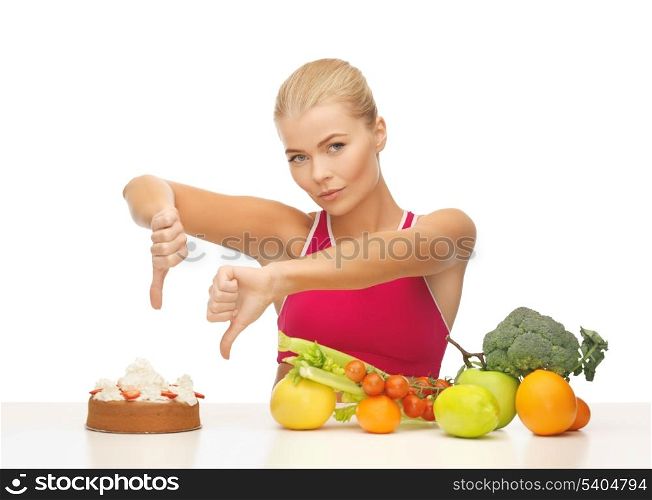 woman with healthy food showing thumbs down to cake