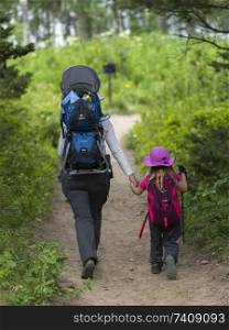 Woman with her daughter hiking on trail, Waterton Lakes National Park, Alberta, Canada