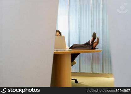 Woman with her feet up on desk