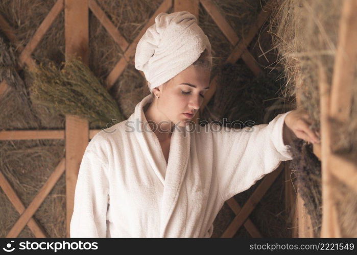 woman with her head wrapped towel relaxing sauna