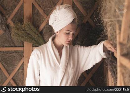 woman with her head wrapped towel relaxing sauna