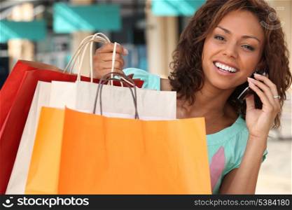 Woman with her shopping bags and talking on her phone