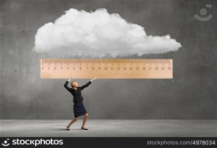 Woman with huge ruler. Young businesswoman measuring something with big ruler