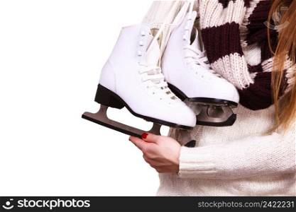 Woman with ice skates getting ready for ice skating, winter sport activity. Girl wearing white wool sweater holding skate shoes in hands on white. woman holding ice skates
