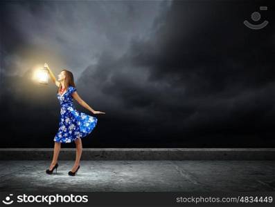 Woman with lantern. Young woman in blue dress with lantern