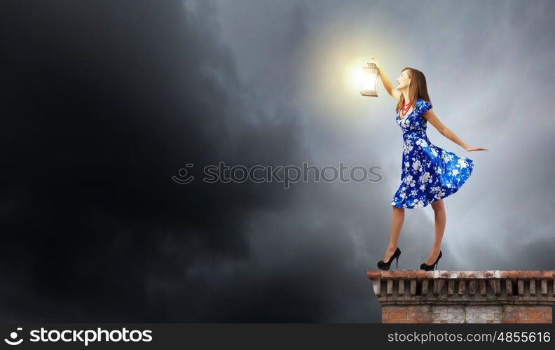 Woman with lantern. Young woman in blue dress with lantern