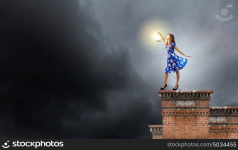 Woman with lantern. Young woman in blue dress with lantern