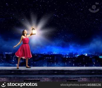 Woman with lantern. Young woman in red dress with lantern