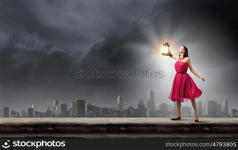 Woman with lantern. Young woman in red dress with lantern