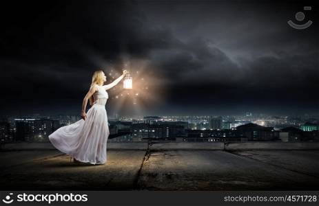 Woman with lantern. Young woman in white long dress with lantern