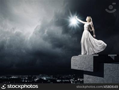 Woman with lantern. Young woman in white long dress with lantern