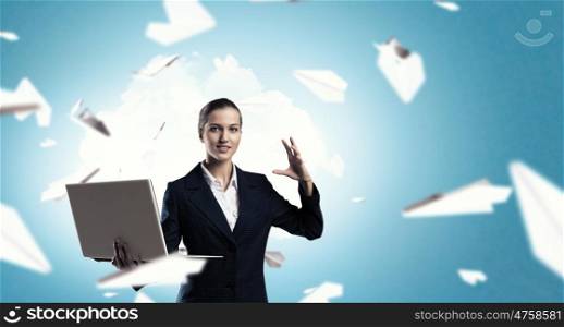 Woman with laptop in hands. Attractive businesswoman with laptop in hands in modern office interior