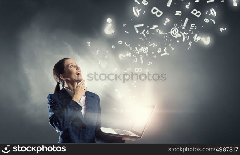 Woman with laptop in hands. Attractive businesswoman with laptop in hands in modern office interior