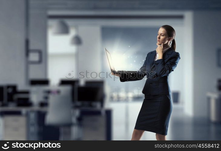 Woman with laptop in hands mixed media. Attractive businesswoman with laptop in hands in modern office interior