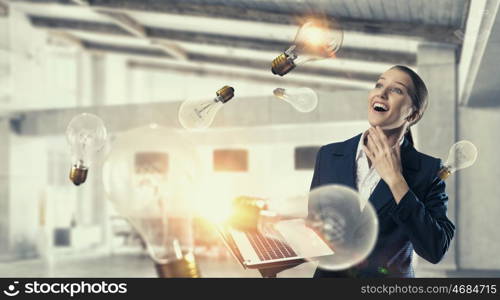 Woman with laptop in hands mixed media. Attractive businesswoman with laptop in hands in modern office interior