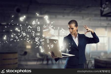 Woman with laptop in hands mixed media. Attractive businesswoman with laptop in hands in modern office interior