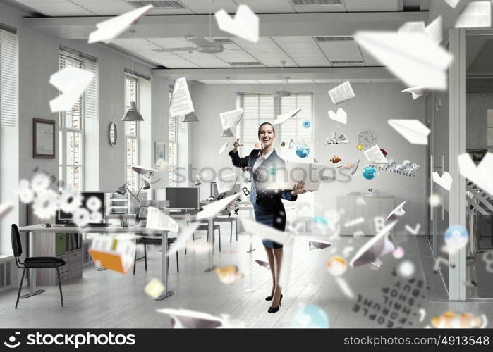 Woman with laptop in hands mixed media. Attractive businesswoman with laptop in hands in modern office interior