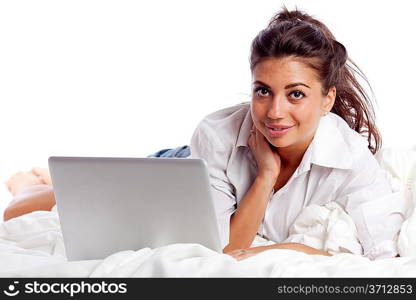 Woman with laptop lying in bed