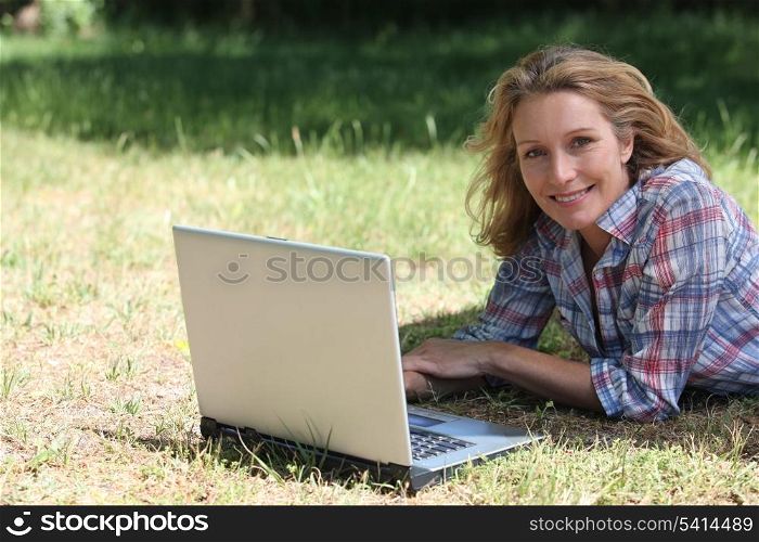 woman with laptop on the grass