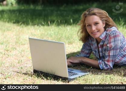 woman with laptop on the grass