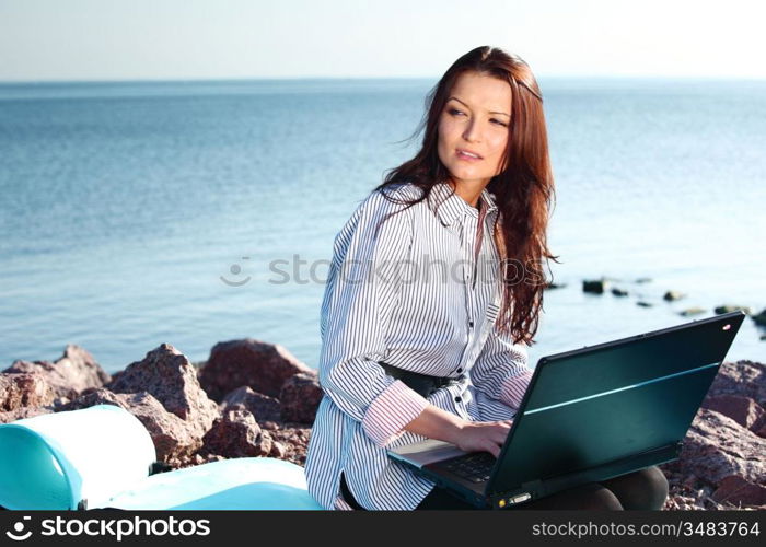 woman with laptop sea background