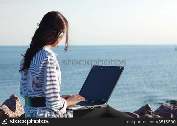 woman with laptop sea background