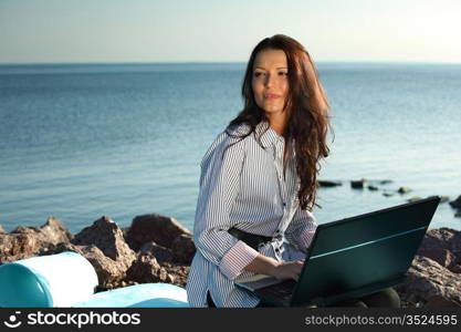 woman with laptop sea background