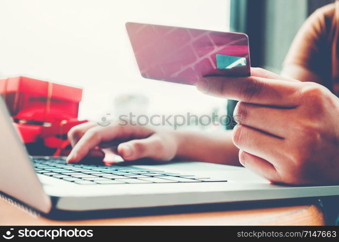 Woman with laptop shopping online with debit card in cafe