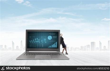 Woman with laptop. Young pretty businesswoman leaning on big laptop