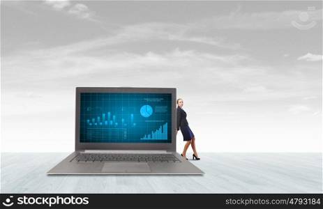 Woman with laptop. Young pretty businesswoman leaning on big laptop