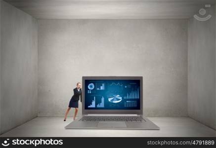 Woman with laptop. Young pretty businesswoman trying to move big laptop