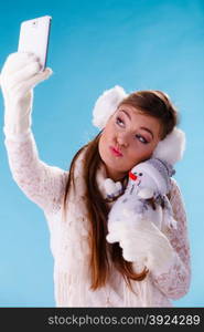 Woman with little snowman taking selfie photo.. Pretty cute woman holding little snowman taking selfie self photo picture with camera. Girl in studio on blue. Winter.