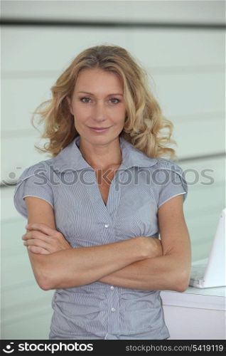 Woman with long blonde hair, arms folded