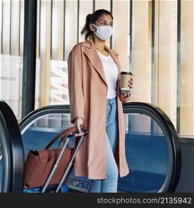 woman with luggage medical mask airport during pandemic