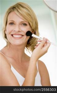 Woman with makeup brush smiling