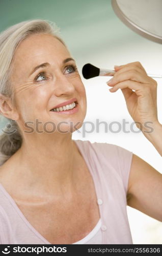 Woman with makeup brush smiling