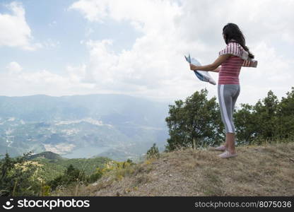 Woman with map high in the mountain. View