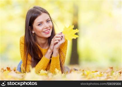 Woman with maple leaf. Portrait of a beautiful young brunette woman with autumn maple leaf