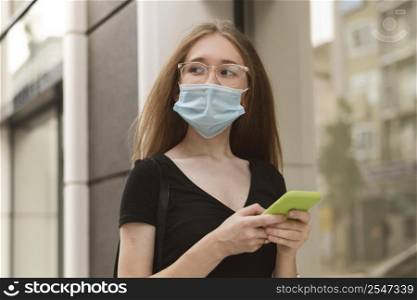 woman with medical mask checking her phone 2