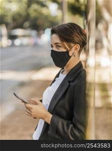 woman with medical mask checking her phone