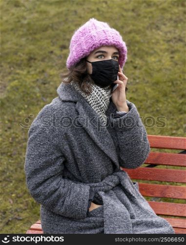woman with medical mask city conversing phone bench 2