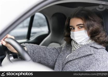 woman with medical mask driving car