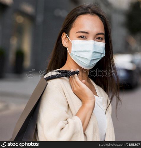 woman with medical mask out sale shopping spree with shopping bag