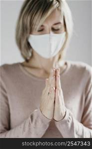 woman with medical mask praying home