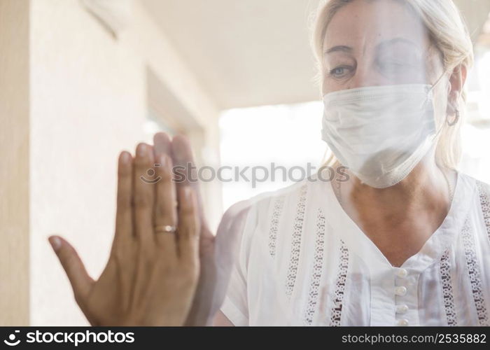 woman with medical mask quarantine window
