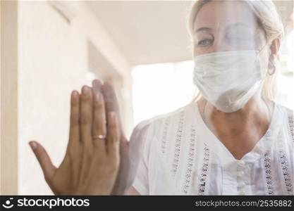 woman with medical mask quarantine window