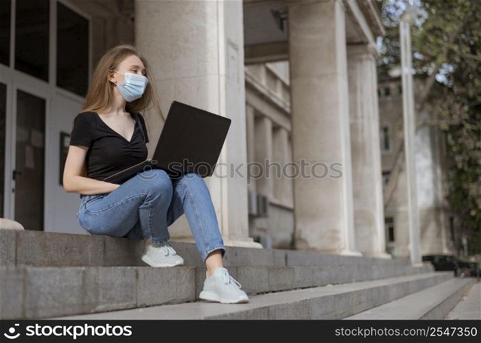 woman with medical mask sitting stairs outside with copy space