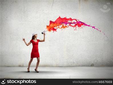Woman with megaphone. Pretty woman in red dress screaming in megaphone