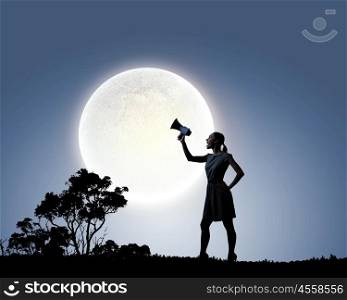 Woman with megaphone. Silhouette of woman at night screaming in megaphone